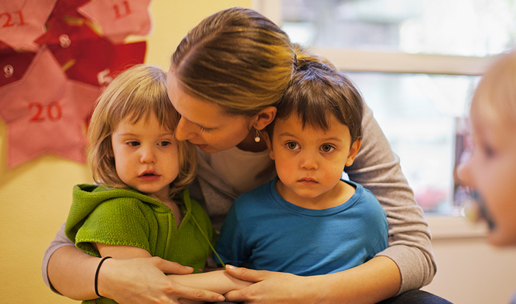 Frau mit zwei Kindern im Arm