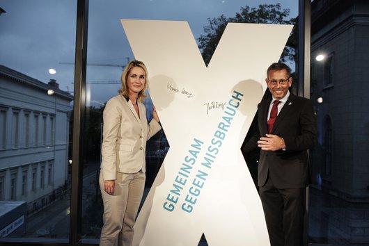 Manuela Schwesig und Johannes-Wilhelm Rörig vor einem großen weißen X, das die Kampagne "Kein Raum für Missbrauch" repräsentiert