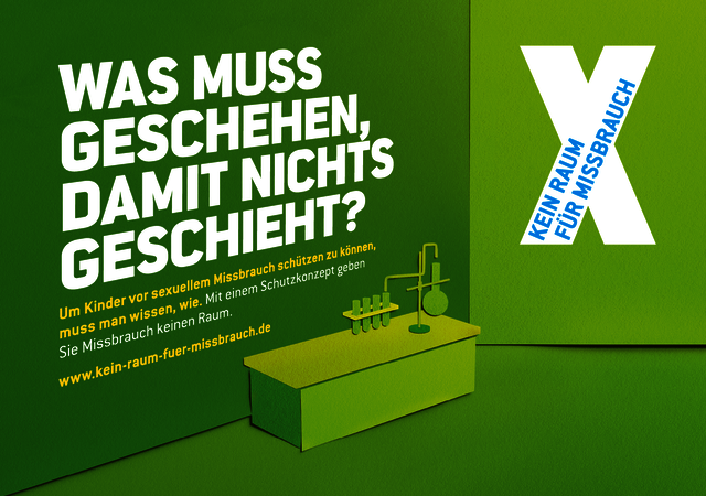 Die Grafik zeigt ein stilisiertes Klassenzimmer in grün, vor dessen linker Wand eine Chemie-Werkbank steht. An der linken Wand steht geschrieben: "Was muss geschehen, damit nichts geschieht? Um Kinder vor sexuellem Missbrauch schützen zu können, muss man wissen, wie. Mit einem Schutzkonzept geben Sie Missbrauch keinen Raum. www.kein-raum-fuer-missbrauch.de." An der rechten Wand ist das Logo der Initiative „Kein Raum für Missbrauch“ zu sehen, das weiße X mit entsprechendem Schriftzug darin.